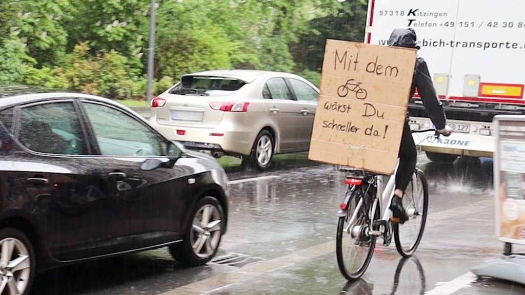 Verkehrswende jetzt: Radfahrer fährt am Stau vorbei - Fotografin: Indra Anders